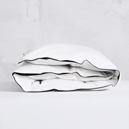 Vitt påslakan i satin med marinblå passpoalkant, tillverkat av ekologisk Giza 86-bomull. Ger en elegant och tidlös hotellkänsla. GOTS- och Fairtrade-certifierat.