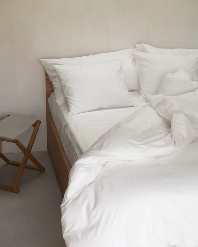 Oglands ekologiska sängkläder i satin och percale, bäddade i en ljus och harmonisk sovmiljö.