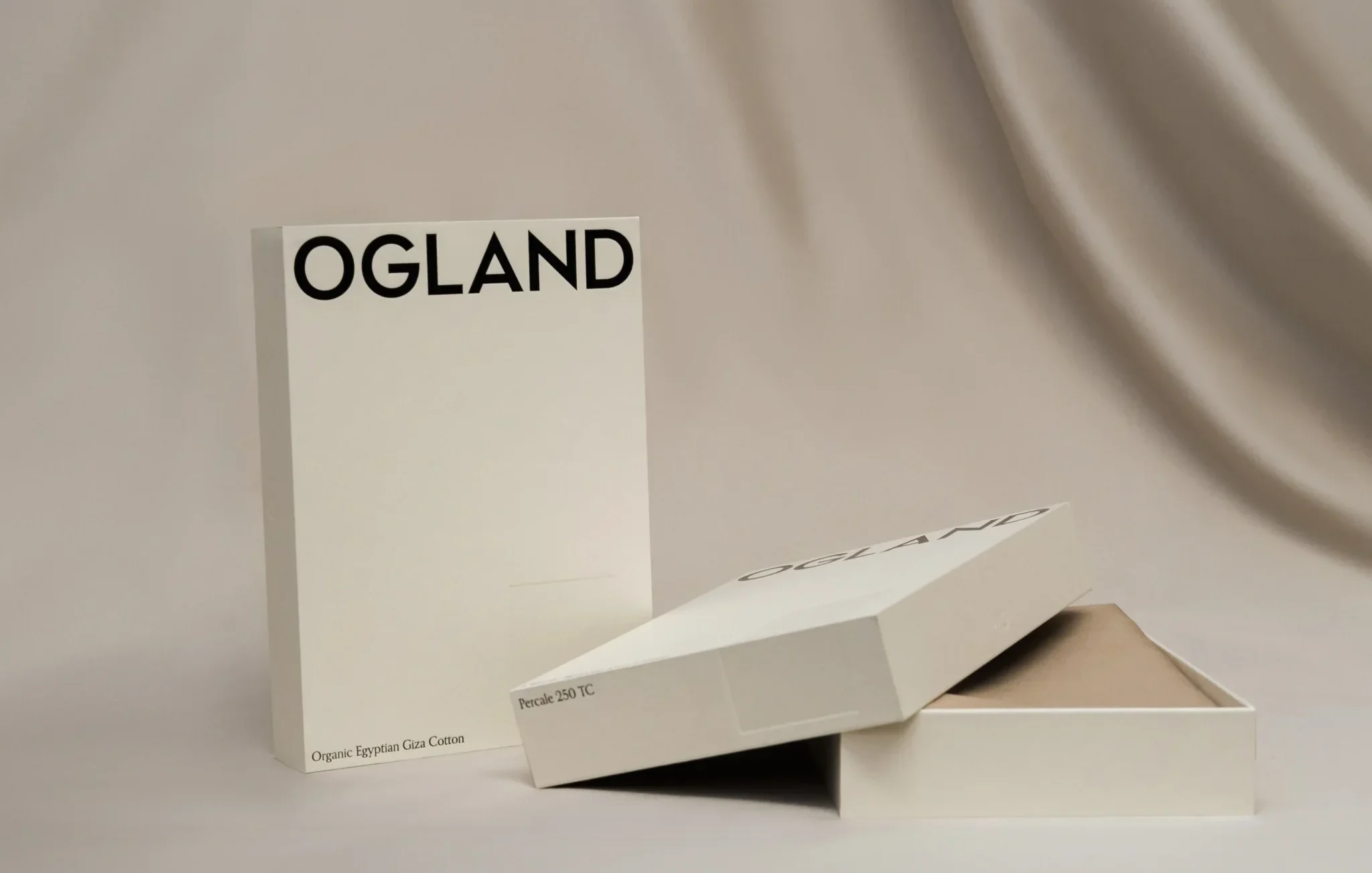 Ogland förpackning i elegant beige nyans med texten "Ogland" – exklusiv design för ekologiska sängkläder i percale av egyptisk Giza-bomull.